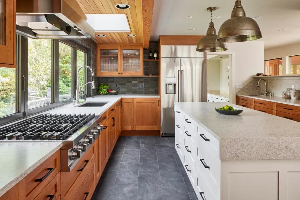 A remodeled kitchen with cherry cabinets, a stone island and a professional range