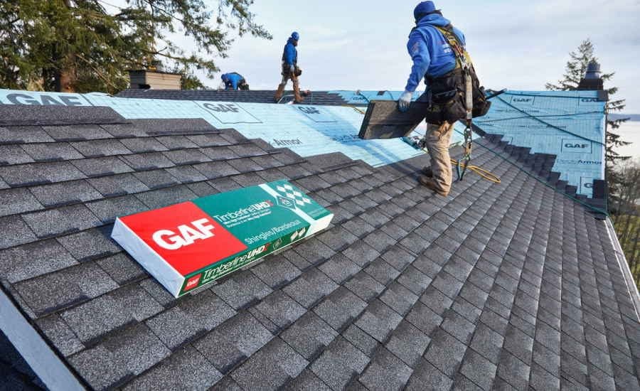 Roofers installing architectural shingles over synthetic underlayment